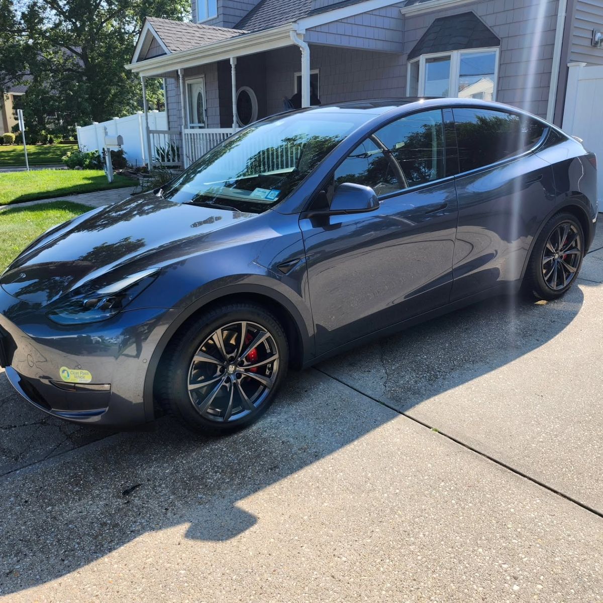 Gray Tesla Model Y with clean black wheels after an exterior detail